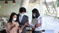 Group of business people in protective mask using digital tablet and discussing business strategy. Royalty Free Stock Photo