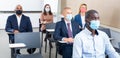 Group of business people in protective masks listening to presentation Royalty Free Stock Photo