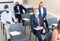 Group of business people in protective masks listening to presentation Royalty Free Stock Photo