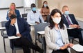 Group of business people in protective masks listening to presentation Royalty Free Stock Photo