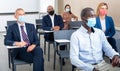 Group of business people in protective masks listening to presentation Royalty Free Stock Photo