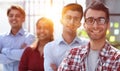 a group of business people smiling in the office lined up with a leader guy Royalty Free Stock Photo