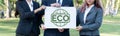 Group of business people stand united, holding eco-friendly idea. Gyre