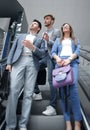 Group of business people standing on the escalator and looking up Royalty Free Stock Photo