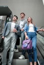 Group of business people standing on the escalator and looking up Royalty Free Stock Photo