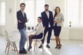 Group of business people standing looking smiling standing at a table in the office Royalty Free Stock Photo