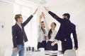 Group of business people standing smiling raised their hands up happy standing at a table in the office. Royalty Free Stock Photo