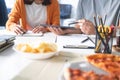 Group of business people talking about project and prepare pizza and potato chips for having lunch in corporate together in office Royalty Free Stock Photo