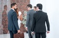 Group of business people talking, standing in the lobby of the business center. Royalty Free Stock Photo