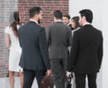 Group of business people talking, standing in the lobby of the business center. Royalty Free Stock Photo