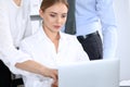 Group of business people using laptop computer while standing in office. Meeting and teamwork concept Royalty Free Stock Photo