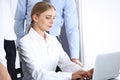 Group of business people using laptop computer while standing in office. Meeting and teamwork concept Royalty Free Stock Photo