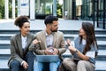 Group of business people walk outside in front of office buildings. Businessman and two businesswomen sharing experience ideas and Royalty Free Stock Photo