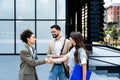 Group of business people walk outside in front of office buildings. Businessman and two businesswomen sharing experience ideas and Royalty Free Stock Photo