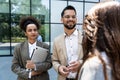 Group of business people walk outside in front of office buildings. Businessman and two businesswomen sharing experience ideas and Royalty Free Stock Photo