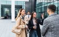 Group of business people walking outside in front of office building. Colleagues discussing on the way to the work. Young Royalty Free Stock Photo