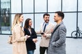 Group of business people walking outside in front of office building. Colleagues discussing on the way to the work. Young Royalty Free Stock Photo