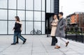 Group of business people walking outside in front of office building. Colleagues discussing on the way to the work. Young Royalty Free Stock Photo