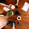 Group of business people working at desk, top view. Weekday work concept. Office stuff and gadgets nearby.Square Royalty Free Stock Photo