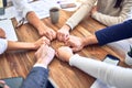 Group of business workers standing bumping fists at the office