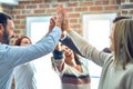 Group of business workers standing with hands together highing five at the office Royalty Free Stock Photo