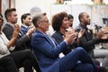 Group Of Businessmen And Businesswomen Applauding Presentation At Conference Royalty Free Stock Photo