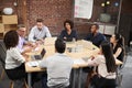 Group Of Businessmen And Businesswomen Meeting Around Office Table