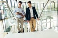 Businessmen and businesswomen walking and taking stairs in an office building