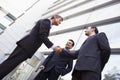 Group of businessmen shaking hands outside office Royalty Free Stock Photo