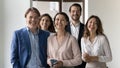 Group of businesspeople standing in office looking at camera