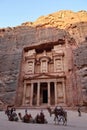 Group of camels in front of the treasury magnificent facade in Petra