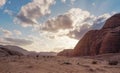 Group of camels walking in orange red sand of Wadi Rum desert, tall rocky mountains background Royalty Free Stock Photo