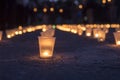 A group of candles burning in street and people holding candles in the background. Day of Memory of the Bereaved