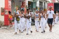 Group of capoeira practitioners walking towards the square