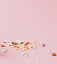 Group of capsules and pills in different colors and shape isolated on pink background Royalty Free Stock Photo