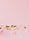 Group of capsules and pills in different colors and shape isolated on pink background Royalty Free Stock Photo