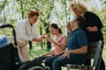 Group of caregivers assisting individuals with special needs during an outdoor activity Royalty Free Stock Photo