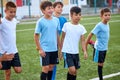 Group of caucasian kid boys stretching legs before football game