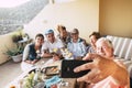 Group of caucasian people men and women celebrate together at home in the terrace - christmas dinner or birthday party - adult man