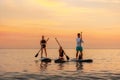 Group of caucasian people swimming on a sup boards at the ocean. Sport activity of friends at the vacation. Summer sport