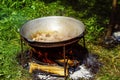 A group of cauldrons and kettle are hanged upon fire