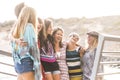 Group of cheerful adult young women friends have fun together laughing a lot with sunlight in background - enjoy friendship and