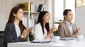 Group of cheerful Asian business people dressed formally sitting in a meeting room hands applauding happily after finish a Royalty Free Stock Photo