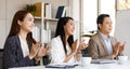 Group of cheerful Asian business people dressed formally sitting in a meeting room hands applauding happily after finish a Royalty Free Stock Photo