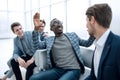 Group of cheerful business people sitting in the lobby of the office. Royalty Free Stock Photo