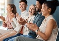 Group of cheerful businesspeople clapping while sitting in a row in a meeting together. Happy business professionals Royalty Free Stock Photo