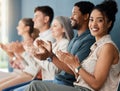 Group of cheerful businesspeople clapping while sitting in a row in a meeting together. Portrait of a young mixed race Royalty Free Stock Photo