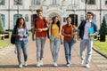 Group of cheerful college students walking out of campus together Royalty Free Stock Photo