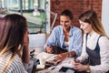 Group of cheerful female students preparing a joint project together in library Royalty Free Stock Photo