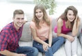 Group of cheerful friends watching videos, sitting on the couch Royalty Free Stock Photo